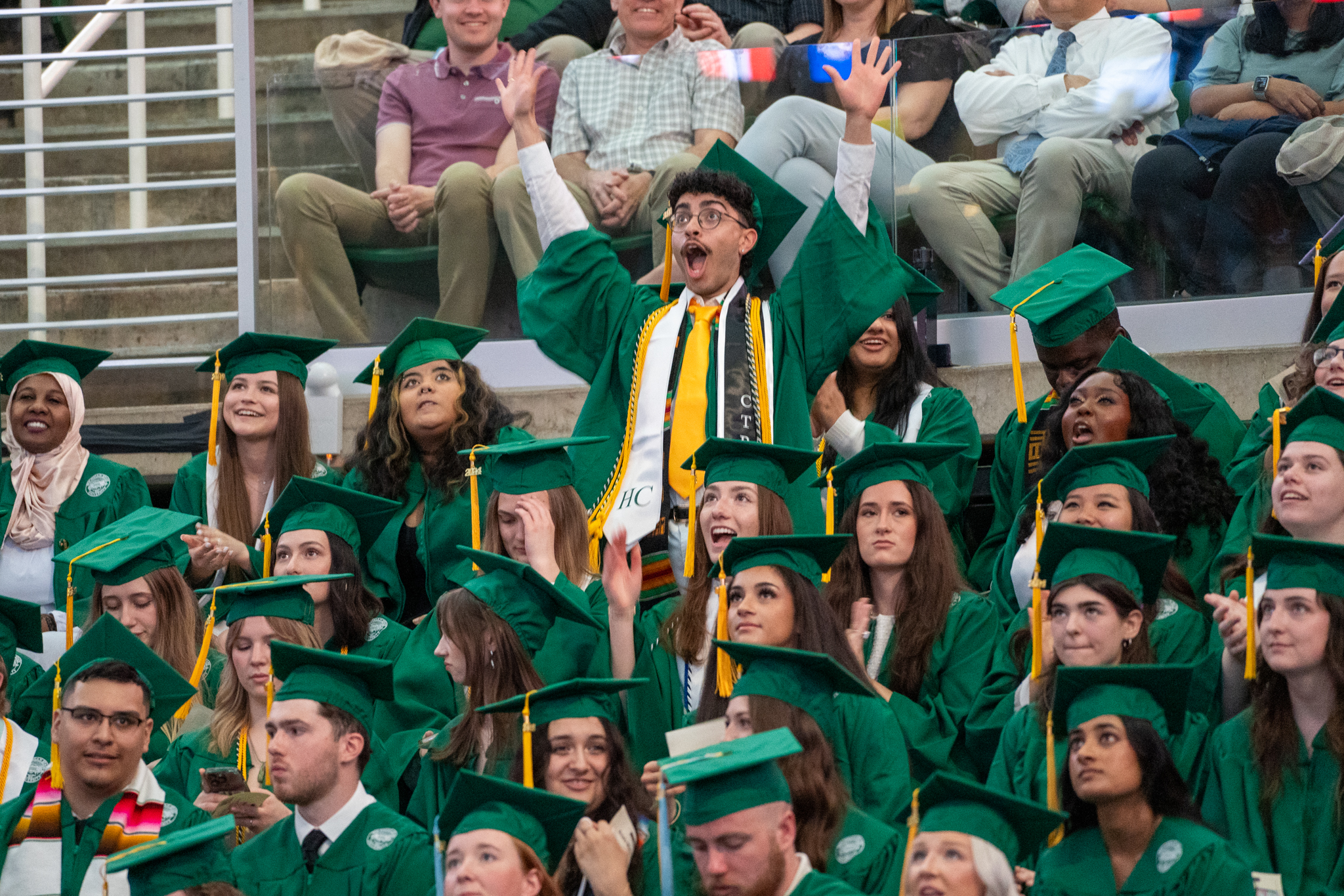 Students in green gowns celebration at commencement